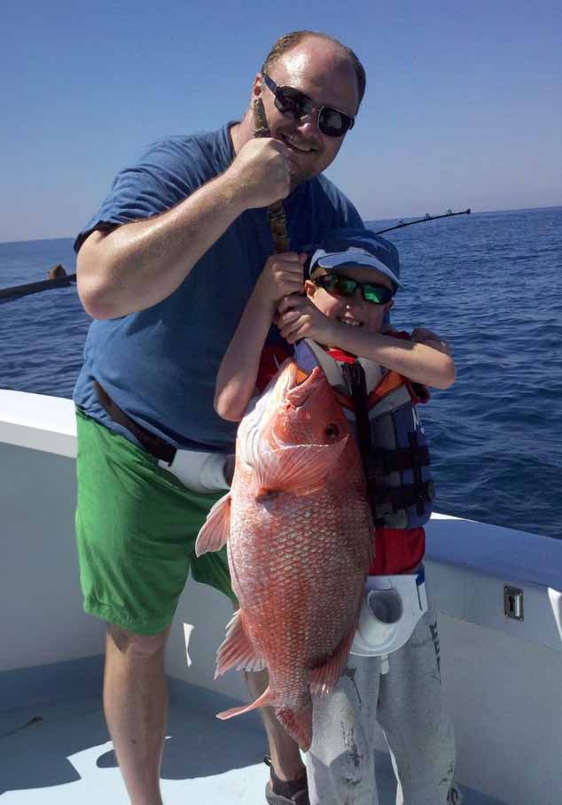 Father and son holding up their recent catch.