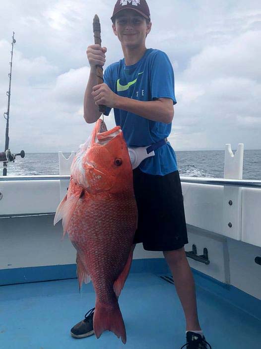 Boy holding catch from Finest Kind Charter Boat