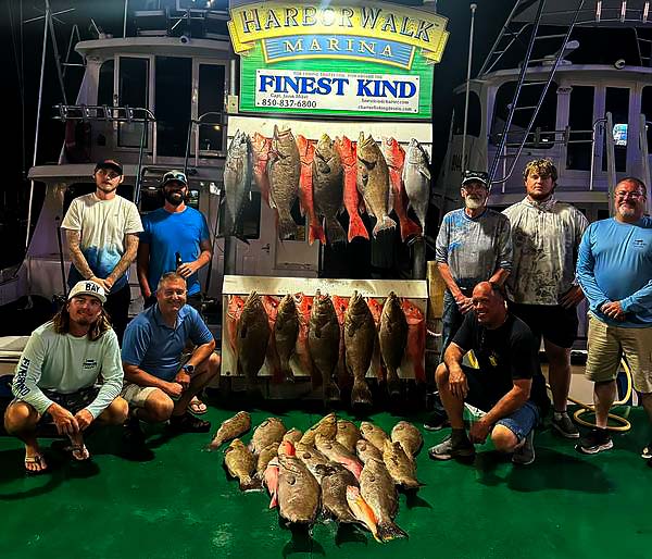 Guests displaying catches from a Finest Kind Charters voyage.